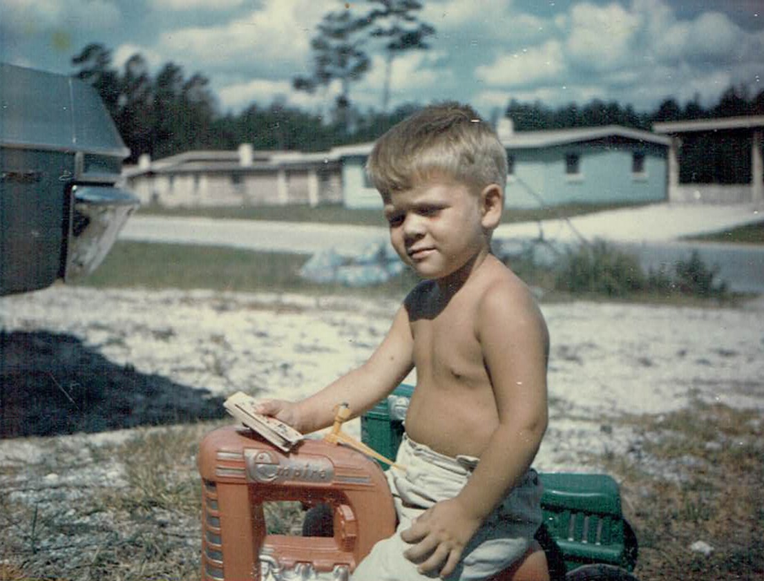 David Blaesing as a young boy on a red toy tractor in Daytona Beach, Florida
